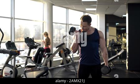 entraînez-vous en salle de sport, musculation musculaire, en faisant des boucles de haltère Banque D'Images