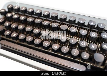 Machine à écrire manuelle, classique en blanc avec un clavier allemand, isolé sur un fond blanc avec un chemin de détourage. Banque D'Images