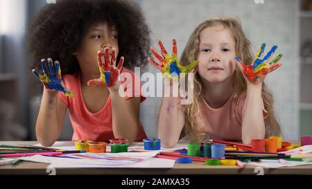 Les enfants multiraciaux visitant la leçon d'art au club, les palmiers dans les peintures, l'enfance heureuse Banque D'Images