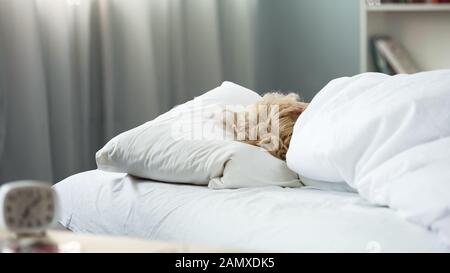 Femme dormant au lit, reposant sur un matelas et un oreiller confortables, récréation Banque D'Images