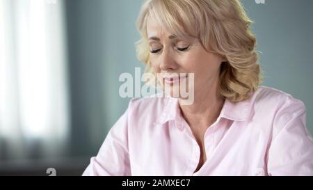 Triste fille pleurant aux yeux fermés se souvenant des jeunes et des moments de santé, vieillissement Banque D'Images