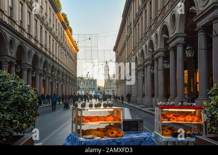 Vue sur le centre historique de Turin avec un stand vendant des beignets dans la rue Via Roma et de la Piazza San Carlo square la veille de Noël, Piémont, Italie Banque D'Images