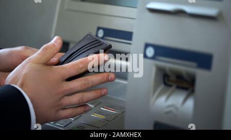 Mains du Mans mettant des euros dans le portefeuille, l'argent retiré de l'ATM, voyager à l'étranger Banque D'Images