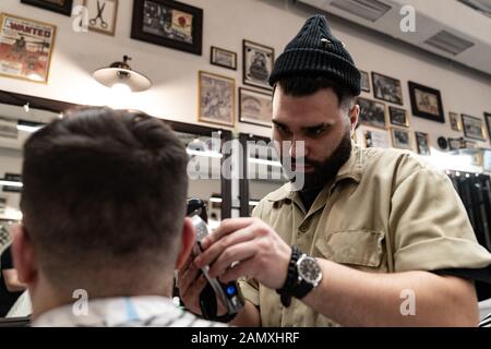 Coupe de cheveux pour homme. Un coiffeur élégant coupe un homme. Banque D'Images