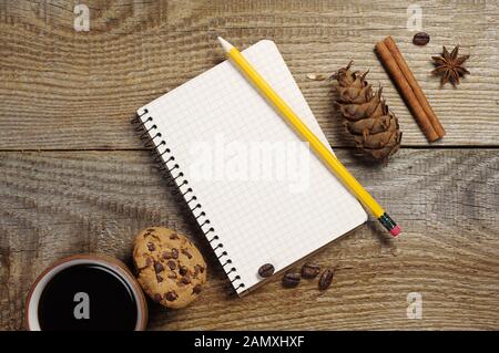 Ouvrir le bloc-notes et tasse de café avec des biscuits au chocolat sur la vieille table en bois. Vue d'en haut Banque D'Images