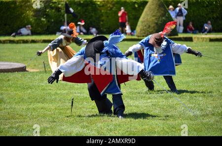 Trois mousquetaires saluant avec leurs épées lors d'une performance qui a eu lieu dans les jardins du Château de Vaux-le-Vicomte, France. Banque D'Images