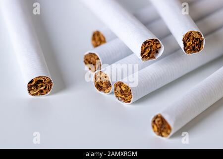 Gros plan d'une pile de cigarettes sur fond blanc Banque D'Images