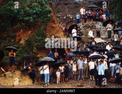 Gruppe von Chinesen stehen mit Regenschirmen an einem Abhang bei Pékin, Chine um 1990. Groupe de Chinois avec des parapluies debout sous la pluie près de Beijing, Chine vers 1990. Banque D'Images