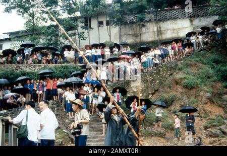 Gruppe von Chinesen mit Regenschirmen an einem Abhang bei Pékin, Chine um 1990. Groupe de Chinois avec des parasols sous la pluie près de Beijing, Chine vers 1990. Banque D'Images