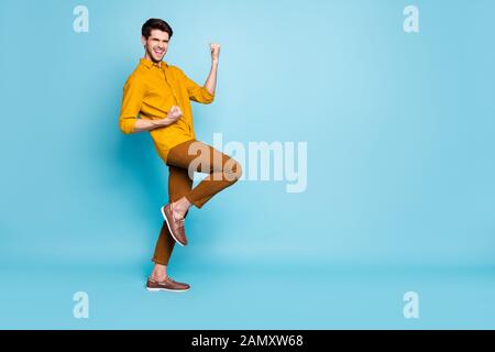 Toute la longueur de la taille du corps photo de joyeux fou excité l'homme chaussures chaussures de joie en hurlant encouragé près de l'espace vide au fil isolé des tons pastel Banque D'Images