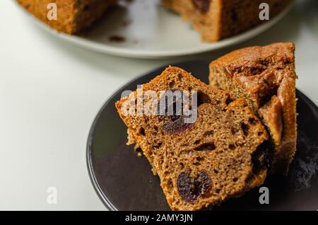 Tranches de gâteau aux fruits épicé délicieux servi sur une plaque en céramique, Gâteau traditionnel britannique Banque D'Images