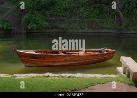 Bateau en bois situé près de la rive de la rivière dans le parc, la solitude et le calme, la relaxation Banque D'Images