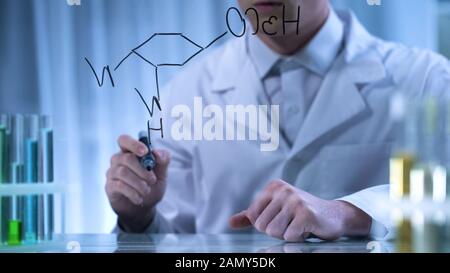 Pharmacien écriture de la formule chimique structurelle sur un conseil transparent, recherche Banque D'Images