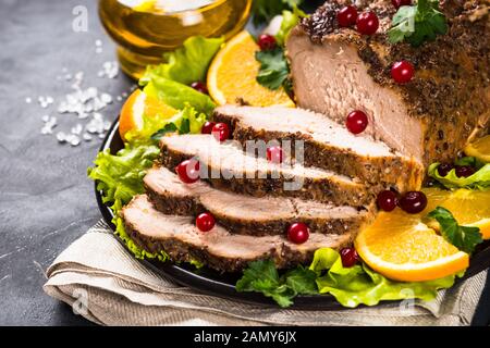 Viande de porc cuite au four avec canneberge et oranges. Banque D'Images