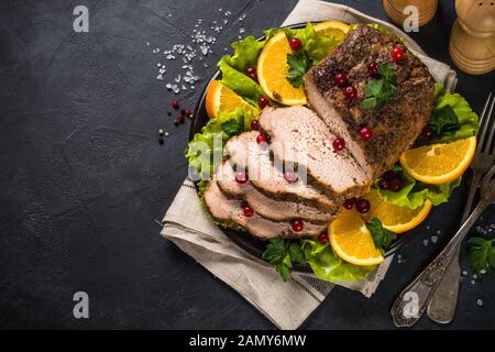 Viande de porc cuite au four avec canneberge et oranges. Banque D'Images