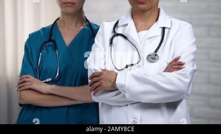 Les collègues médicaux qui croissent les mains, les professionnels toujours prêts à aider le patient Banque D'Images