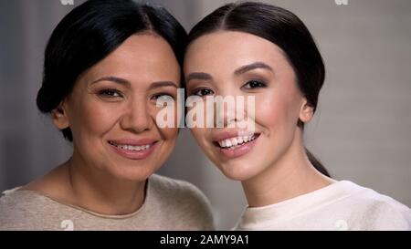 La mère et la fille asiatiques joyeuses riant, regardant la caméra, fait face à la proximité Banque D'Images