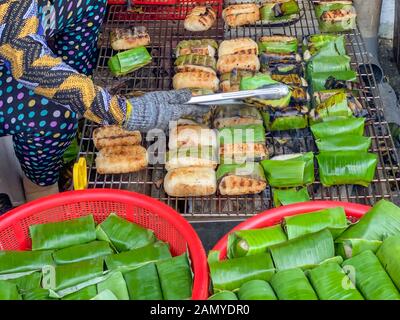 Cuisson du riz collant femme banana au Cambodge marché plein air Banque D'Images