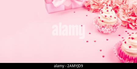 Amour saint valentin décoration cupcake à la crème et rose fleurs et coeurs sur fond rose cadeaux avec copie espace pour le texte Banque D'Images