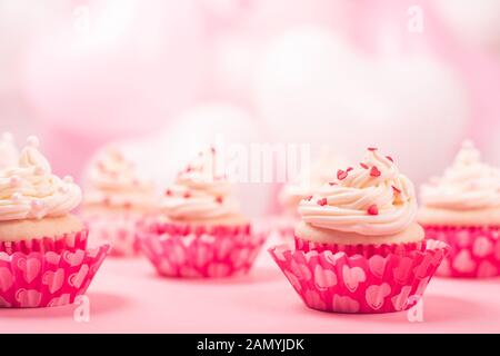 Valentine day love cupcakes décoration crème et coeurs rose et blanc sur fond de ballons parti avec copie espace pour le texte Banque D'Images