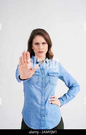 Déplut femme montrant un panneau d'arrêt au studio shot Banque D'Images