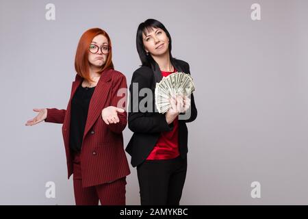 Riche business woman smiling holding tas de l'argent en espèces isolées sur fond blanc Banque D'Images