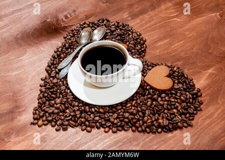 Tasse à café blanc, d'épices en forme de coeur et deux cuillères sur une base en forme de coeur fait avec des grains de café - image Banque D'Images