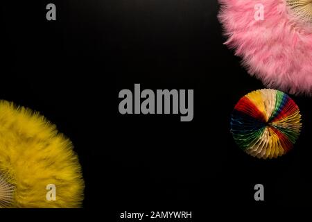 Carnaval des objets sur un fond noir. Rose et jaune, des fans chinois objet forme cercle de papier Banque D'Images