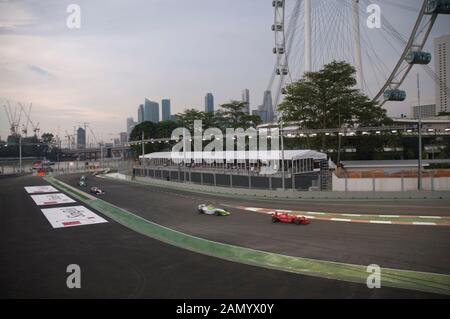 Les voitures de course de Formule 2 avec Central Business District et Singapore Flyer en arrière-plan, Grand Prix de Singapour, Central Business District, Singapour Banque D'Images