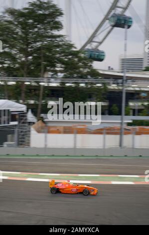 Les voitures de course de Formule 2 avec le Singapore Flyer en arrière-plan, Grand Prix de Singapour, Central Business District, Singapour Banque D'Images