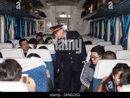 (200115) -- TAIYUAN, 15 janvier 2020 (Xinhua) -- le chef d'orchestre du train Zhao Yao travaille sur le train K884, 11 janvier 2020. Alors que des millions de Chinois renouent avec le festival de la veille du printemps, le nouvel an lunaire de la Chine, Zhao Yao et Chen Haiyan, un couple travaillant tous deux comme chefs d'orchestre sur les trains, rateront à nouveau l'anniversaire de leur fille qui tombe le même jour de la veille, Aussi l'occasion la plus importante de réunion de famille pour les Chinois. Il n'y a que trois fois que le couple passe l'anniversaire avec sa fille depuis qu'elle est née en 2008. Zhao et Chen se sont rencontrés et sont tombés dans l'amour quand ils étaient Banque D'Images