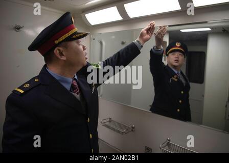 (200115) -- TAIYUAN, le 15 janvier 2020 (Xinhua) -- le chef d'orchestre du train Zhao Yao vérifie l'état sanitaire du train K884 de Taiyuan de la province de Shanxi en Chine du nord à Qingdao de la province de Shandong en Chine orientale, le 11 janvier 2020. Alors que des millions de Chinois renouent avec le festival de la veille du printemps, le nouvel an lunaire de la Chine, Zhao Yao et Chen Haiyan, un couple travaillant tous deux comme chefs d'orchestre sur les trains, rateront à nouveau l'anniversaire de leur fille qui tombe le même jour de la veille, Aussi l'occasion la plus importante de réunion de famille pour les Chinois. Il n'y a que trois fois pour que le couple passe le Banque D'Images