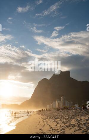 Coucher de soleil depuis la plage de Sao Conrado à Rio de Janeiro, avec la montagne de granit de mer Pedra da Gavea. Banque D'Images