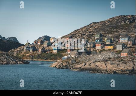 Des maisons colorées parsement les collines de la ville de pêcheurs de Kangaamiut, à l'ouest du Groenland. Icebergs du glacier de Kangia au Groenland nageant avec le ciel bleu Banque D'Images