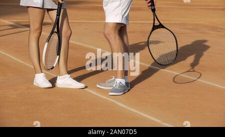 Homme et femme debout sur le court et parler du dernier match de tennis, passe-temps Banque D'Images