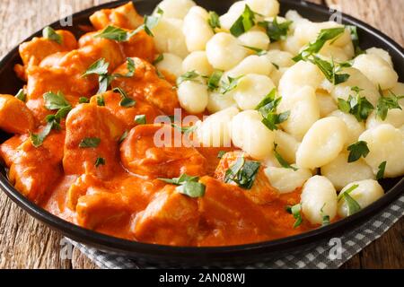 Tendres morceaux de poulet dans une sauce crémeuse parfumée, cette paprikash de poulet se ferme sur une plaque sur la table. Horizontale Banque D'Images