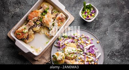 Bannière alimentaire. Cuisses de poulet au four avec des pommes de terre, le fromage et les oignons verts à salade rouge. Vue d'en haut Banque D'Images