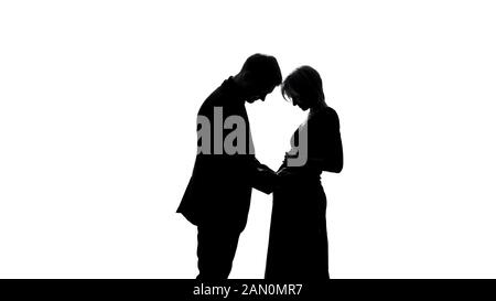Jeune homme ombre embrassant le ventre de la femme enceinte, en attendant couple, bonne parentalité Banque D'Images