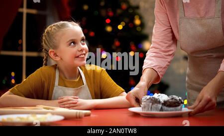 Femme âgée mettant des muffins au chocolat sur table, préparations de Noël, vacances Banque D'Images