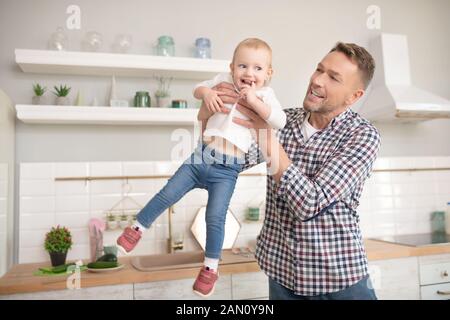 Père en chemise à carreaux s'amusant avec sa petite fille Banque D'Images