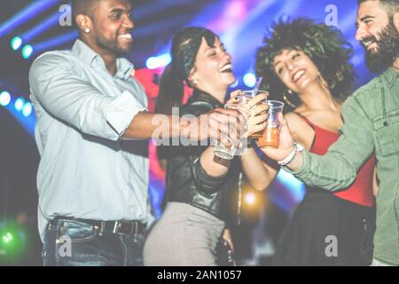 Professionnels divers la culture amis avoir parti au club de nuit - Les jeunes s'amusant cheering with cocktails at disco dance floor - concept de la jeunesse - F Banque D'Images