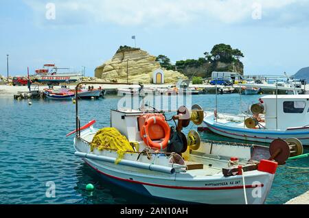 Zakynthos, Grèce - 24 mai 2016 : petit port avec bateaux et chapelle à Agia Sostis sur l'île grecque dans la mer Ionienne Banque D'Images