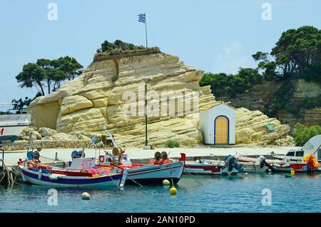 Zakynthos, Grèce - 24 mai 2016 : petit port avec bateaux et chapelle à Agia Sostis sur l'île grecque Banque D'Images