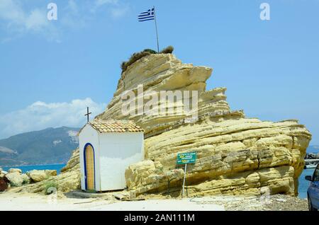 La Grèce, l'île de Zakynthos, chapelle et rocher avec drapeau grec à Agia Sostis Banque D'Images
