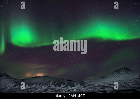 Vue incroyable sur aurora borealis, lumière verte magique illuminant dans le ciel nocturne, forces de la nature, merveilleux paysage islandais Banque D'Images