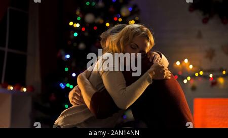 Un couple tendre et génial s'embrassant près de l'arbre de Noël, célébrant les vacances, l'amour Banque D'Images