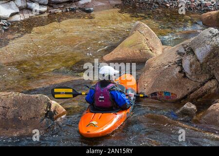 Groupe d'adolescents de la formation dans des kayaks à Etive River Falls, Glencoe, Highlands, Scotland, UK en mars - kayakiste unique Banque D'Images