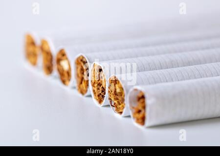 Gros plan d'une pile de cigarettes sur fond blanc Banque D'Images