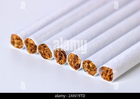 Gros plan d'une pile de cigarettes sur fond blanc Banque D'Images