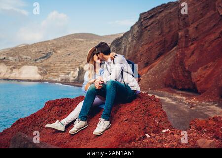 Saint Valentin. Couple amoureux de lune de miel sur la plage rouge sur l'île de Santorin, Grèce. Vacances et voyages Banque D'Images